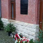 81. rocznica wybuchu II wojny światowej: kwiaty pod tablicą pamiątkową na ścianie budynku dworca PKP w Opolu